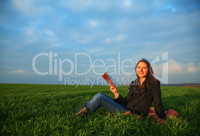 Teen girl reading the Bible outdoors