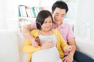 Asian pregnant woman having medicine at home