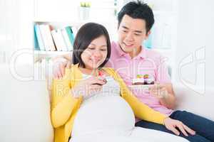 Asian pregnant woman eating cake