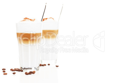 latte macchiato vor anderer latte macchiato mit kaffee bohnen und schokopulver