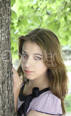 Portrait of a girl in a tree trunk