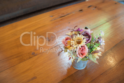 Beautiful colors of plastic flowers on wood table