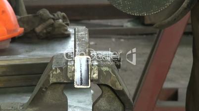 close-up of circular saw cuts metal, sparks fly