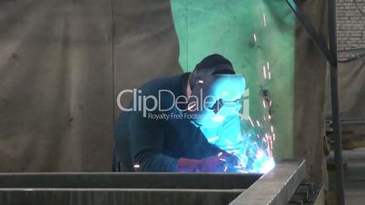 man wears a mask and start welding, workflow at the plant