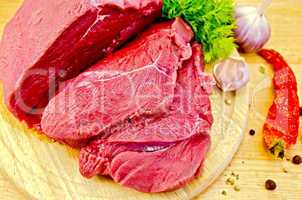 Meat beef on a wooden board with vegetables