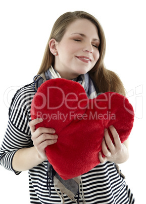 beautyful young and smiling woman embraces heart shaped pillow with her hands