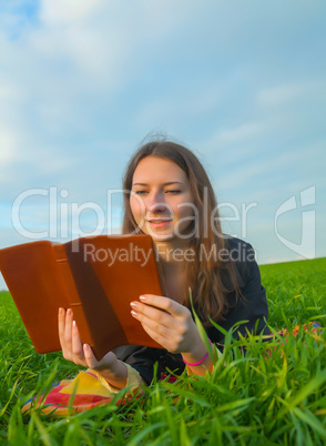 Teen girl reading the Bible outdoors