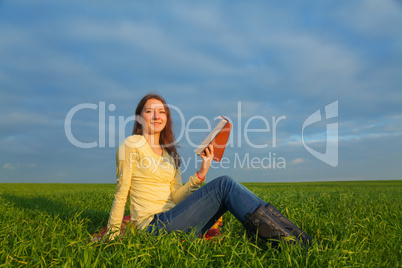 Teen girl reading the Bible outdoors