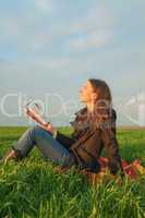 Teen girl reading the Bible outdoors