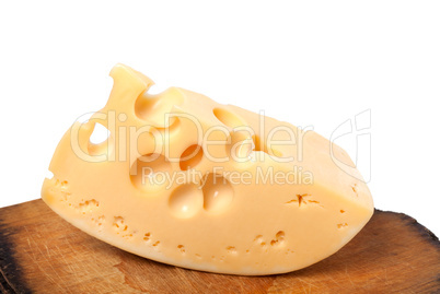 Piece of cheese on old wooden kitchen table