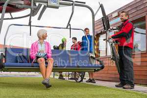 Happy couple sitting chair lift with bicycle