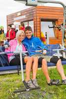 Smiling couple sitting and waiting on chair-lift