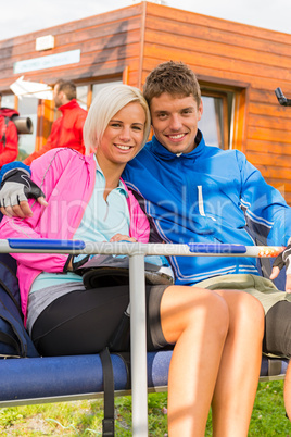 Smiling young couple sitting together char lift