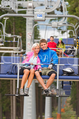 Cuddling young couple sitting on chair lift