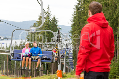Young couple enjoying chair lift in wood