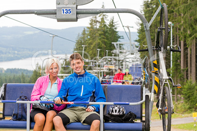 Chair lift going through forest couple sitting