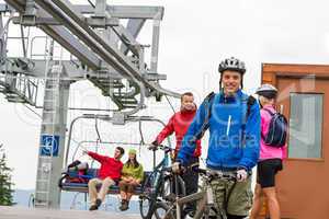 Couple getting on bicycles chair lift trip