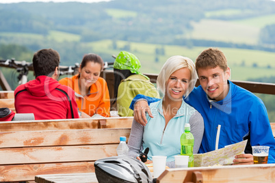 Cuddling couple reading map scenic view background