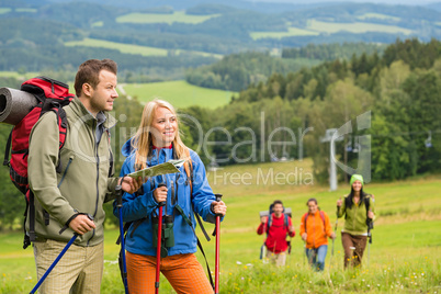 Young hikers reading map in natural landscape