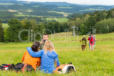 Hiker with camera taking picture resting friends