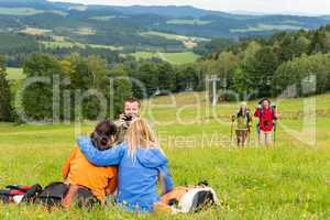 Hiker with camera taking picture resting friends