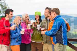 Happy friends clinking glasses drinking beer outdoors