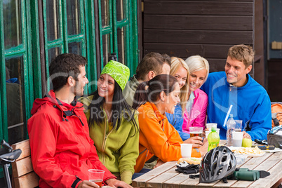 Smiling young friends talking with beer outdoors