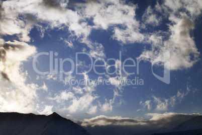 Blue sky with clouds and mountains in evening