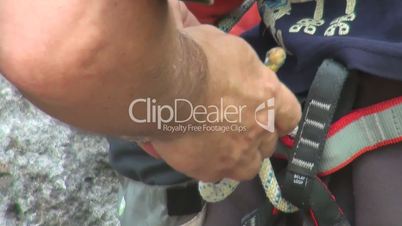 climber ties a knot in the rope