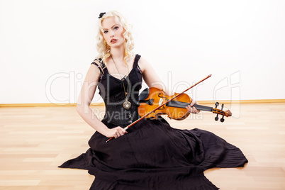 Woman sitting on the floor and plays violin