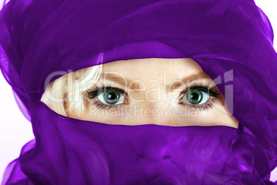 Face of a veiled blonde woman