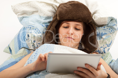 Das junge Mädchen liegt krank im Bett und schaut in ihr Tablett