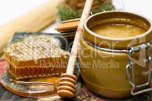 Honey in pot, honeycomb and stick