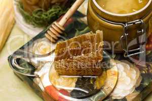 Honey in pot, honeycomb and stick