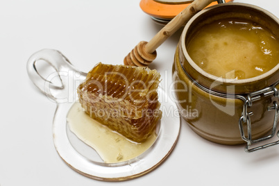 Honey in pot, honeycomb and stick