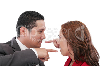 Young couple pointing at each other against a white background