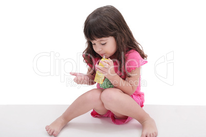 Close-up of beautiful little girl drinking from a juice box. Sho