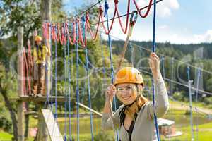 Woman climbing on rope ladder adrenalin park