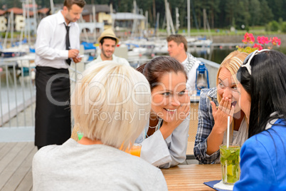 Gossiping women sitting at harbor bar