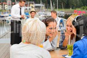 Gossiping women sitting at harbor bar