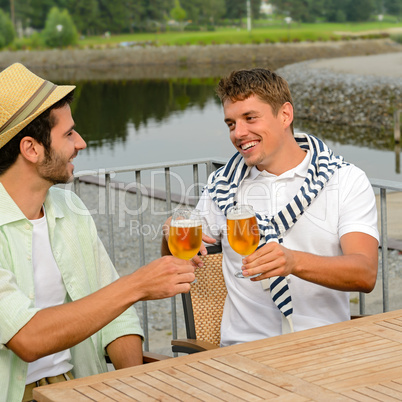 Cheerful male friends drinking beer at pub
