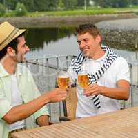 Cheerful male friends drinking beer at pub