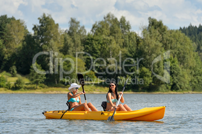 Happy girls kayaking on sunny day