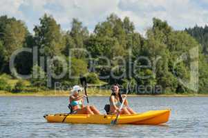 Happy girls kayaking on sunny day