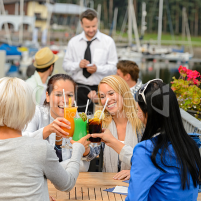 Women celebrating with cocktails at restaurant