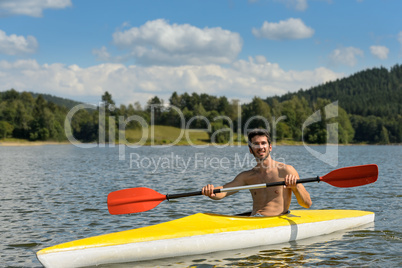 Sporty man in kayak with oar summer