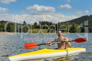 Sporty man in kayak with oar summer