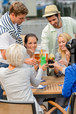 Group of cheerful people toasting with cocktails