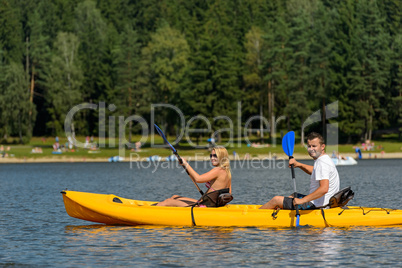 On pond young couple sitting in kayak