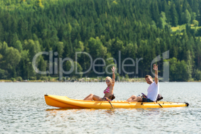 Man and woman kayaking on pond vacation
